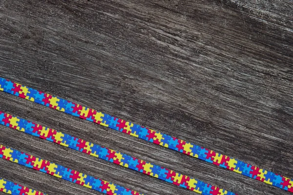 World Autism awareness day with Puzzle ribbon on wooden background