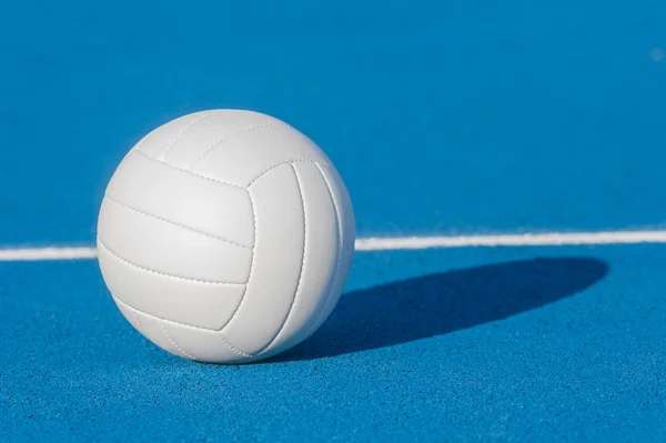 Volejbalová koule na modrém hřišti s bílou čárou — Stock fotografie