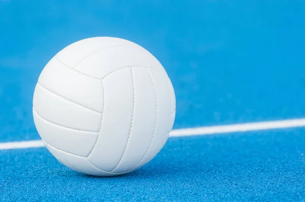 Volleybal bal op blauwe speelplaats met witte lijn — Stockfoto