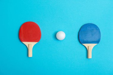 Mavi arka planda masa tenisi oynamak için iki raket.
