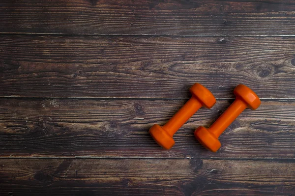 木制桌子上的橙色哑铃 健康健康与体育概念 — 图库照片