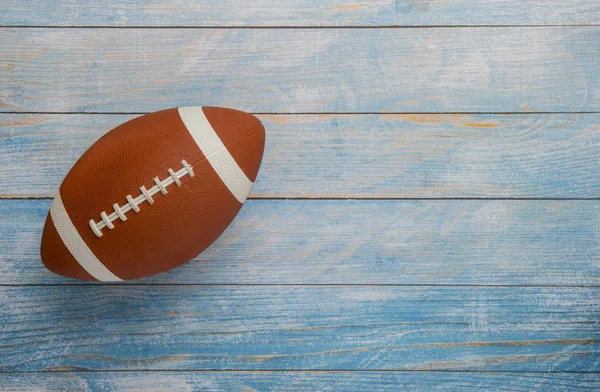 American football ball on wooden background