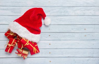 Arkaplanda Noel Baba şapkası olan hediye kutuları.