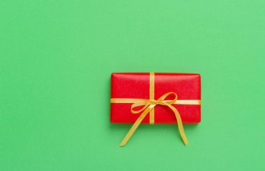 Yeşil arkaplana yerleştirilmiş Noel hediyesi kutusu