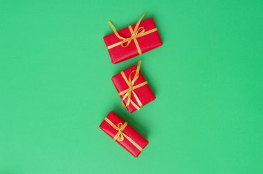 Yeşil arkaplana yerleştirilmiş Noel hediyesi kutuları