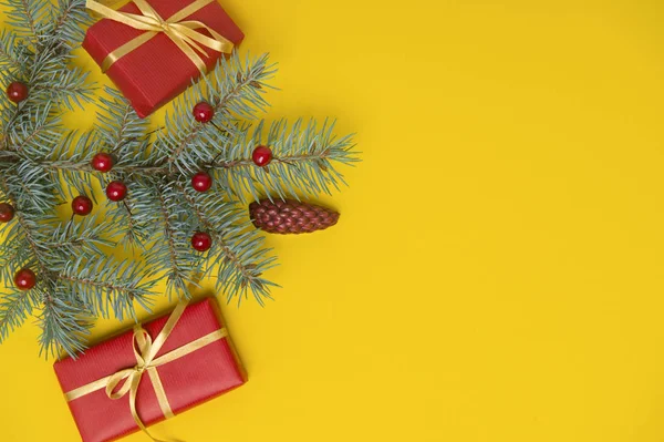 Christmas gift box with decoration on yellow background. Top view