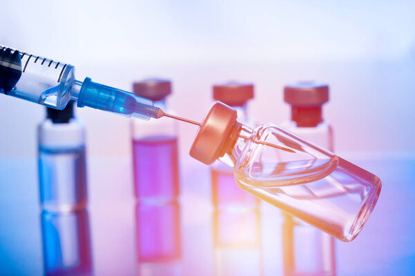 Close-up medical syringe with a vaccine. Vaccination and healtcare concept.