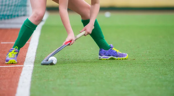 Jogador de hóquei em campo treinando e praticando o esporte na grama