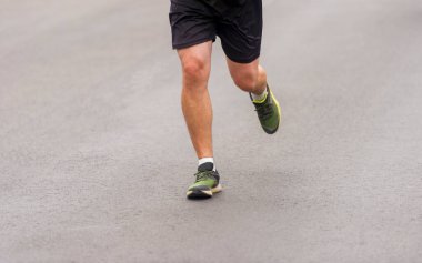 Koşucu ayaklarını kapat. Fitness arka planı, yolda koşan ayakların kapatılması.