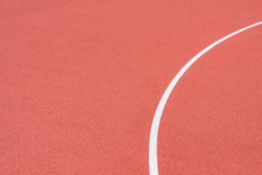 Suni kırmızı bir sahada, bir sokak basketbolunda, hentbolda, voleybolda, futsal 'de, rugby' de, hokeyde ve futbol sahasında, bir spor sahasında.