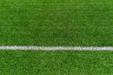 Yeşil sentetik çim spor sahası, yukarıdan beyaz çizgili. Futbol, ragbi, futbol, beyzbol sporu konsepti.