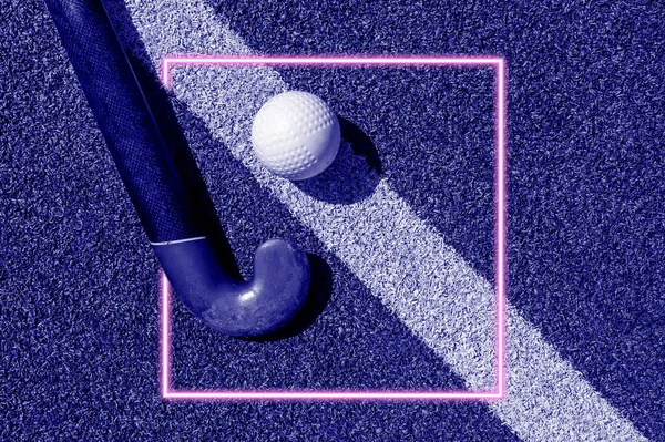 Field hockey stick and ball on field.  Team sport concept. Blue color filter.