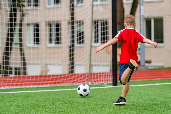 Football soccer training for kids. Boy running and kicking soccer ball. Young boy improving soccer skills