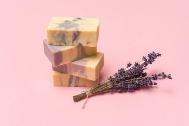 Doğal el yapımı sabun, kurutulmuş lavanta ve pembe arka planda gerekli yağ. Sıfır atık