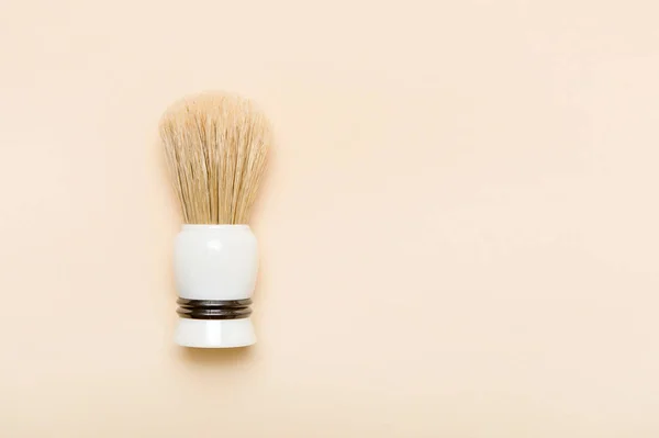 Shaving brush on cream color background. Zero waste concept