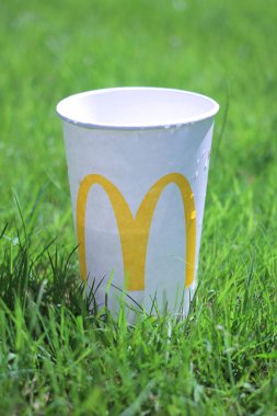 McDonald 'ın bardağı yazın yeşil çimlerin üzerinde.