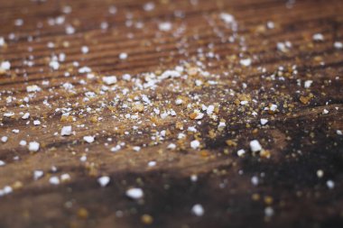 Mutfak ahşap masa yüzeyi un, fındık, yemek artıkları ve kırıntılarla dolu. Sığ odak