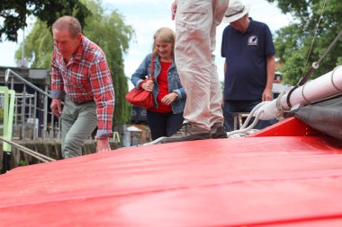 Yelkenliden inen insanlar. Yaşlı insanlar tekneden ayrılıyor.