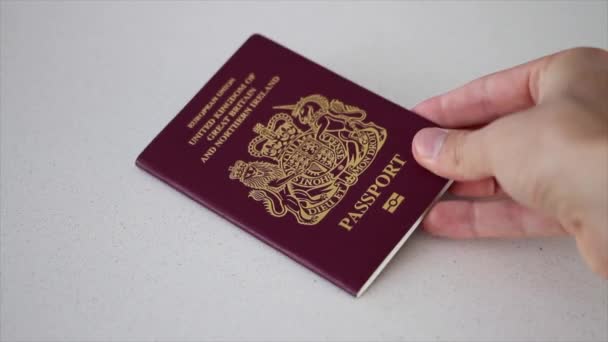 Mão pousando e pegando um passaporte do Reino Unido antes do Brexit da UE (União Europeia) — Vídeo de Stock