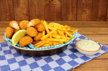 Scampi ve patates kızartması yemek ahşap arka plan üzerinde tartar sos ile