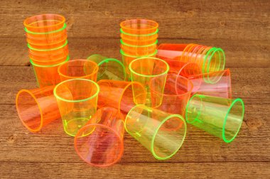 Ahşap arka plan üzerinde plastik shot bardak grubu