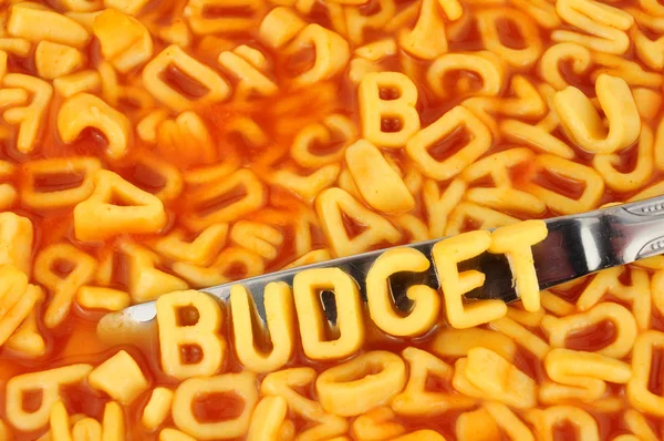 字母意大利面拼写预算与随机字母在番茄酱背景 — 图库照片