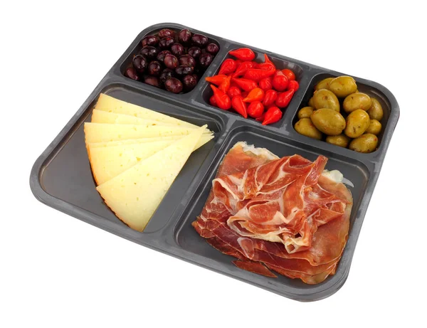 Tray of supermarket Spanish tapas with Serrano ham, Queen green olives, sweet flame peppers and Manchego cheese isolated on a white background