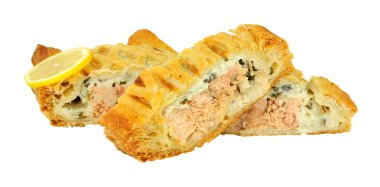 Dilimlenmiş puf böreği, beyaz bir arka planda izole edilmiş peynirli ıspanak ile kaplı somon Wellington.