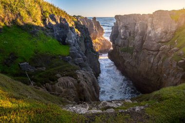 Sunset at Punakaiki pancake rocks and blowholes in the west coast of New Zealand's south island clipart