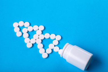 Noel ağacı hap mavi zemin üzerine beyaz boş plastik şişeyi manzaralı.