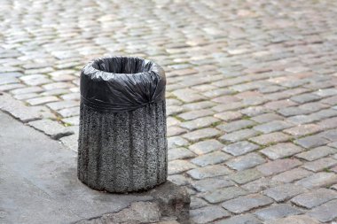 Kaldırım taşları ile kopya alanı metin için bir yaya kaldırımda bir beton bin çöp torbasına monte.
