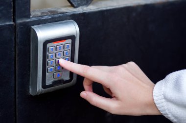 El erişim kodu elektronik kilit güvenlik kilidi el ile close-up bir mavi aydınlatmalı bir parmak basarak çeviren.