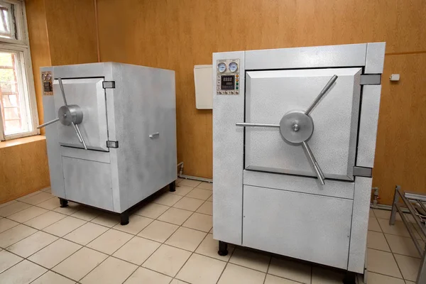 Industrial large autoclave for disinfection of medical supplies, 2 devices of the medical industry in the room.