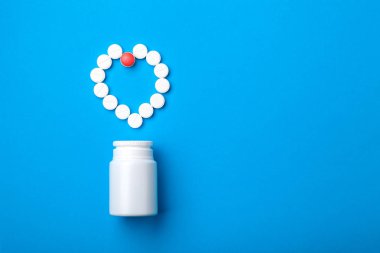 kavram ilaç tıp hap, tablet kalp ve şişe üstten görünüm mavi zemin üzerine şeklinde sıralanır. Metin için yer kopyalayın.