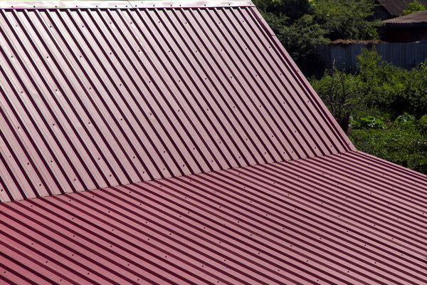 gable roof top view, roof overlap with corrugated metal of red color.