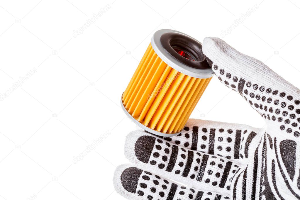 The hand of an engineer in a glove holds a new clean automobile filter for cleaning the gearbox oil. Car filter orange color in hand isolated on white background with empty copy space for text.