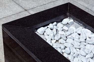 Saksının beyaz taşlarla kaplı ve siyah mermer ile dekore edilmiş.