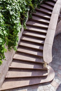 Taş merdiven korkuluk ve korkuluklar ve yeşil bitkiler ile mermer merdiven duvardaki bir güneşli gün üstten görünüm mimarisine ile.