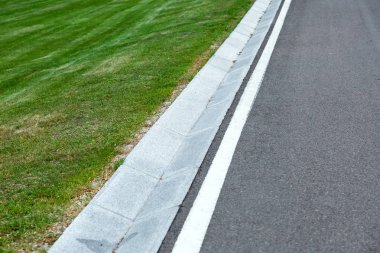 İşaretler ve çim ile bir yolun kenarında bir yağmursuyu drenaj sisteminin sokak cilt payı.