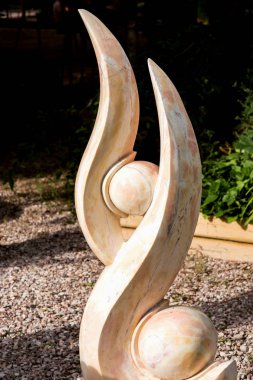 çakıl üzerine parkta bej taş mermer heykel, sanat nesnesi.