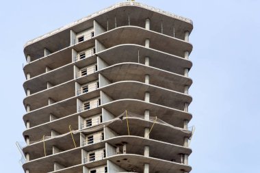 Gökyüzünün altında destekleyici sütunlar ile monolitik tipte çok katlı bir ofis binası inşaatı, kimse.