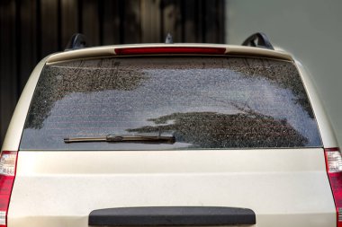 kirli bir arabanın arka görünümü, tozlu bagaj kapağı ve hatalı bir araba silecek ile hatchback.
