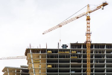 Sarı kule vinç inşaat malzemeleri inşaat aşamasında bir çok katlı yüksek katlı binanın üstüne asansörleri.