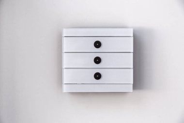 Beyaz duvara monte edilmiş göstergelere sahip modern beyaz cam dokunuşa duyarlı ışık anahtarı.