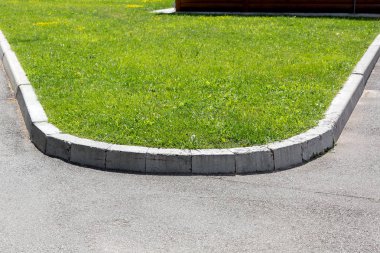 güneşli bir yaz gününde yeşil çim ile arka plan çim bir taş kaldırım ile bir asfalt yol kenarı.
