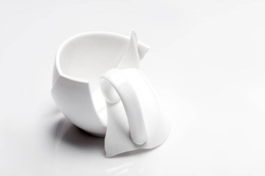 Parçaların parçaları beyaz bir yüzeye düştükten sonra sapı kırık bir bardak, bir kopya alanı, krizin çöküşü konsepti.