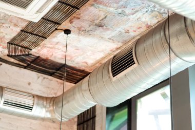 Odanın havalandırma sistemi binanın tavanına tavan arası tarzında yerleştirilmiş. Izgaralı boruları kapatın..