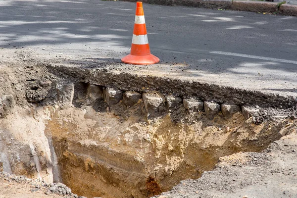 The road repair work and caution with blocked barrier over concrete digging.