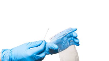 Doktor eli mavi steril eldivende kapalı torba tutuyor ve virüs testi için ağız boşluğundan örnek almak için pamuk örneği veriyor, beyaz arka planda izole edilmiş tıbbi temayı taklit ediyor..