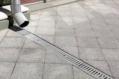 Yerdeki karolardan gri taş granit kaldırımların demir drenaj ızgarası ile ön cephe binasında galvanize olmuş iniş, şehir altyapısını kapatma, hiç kimse.